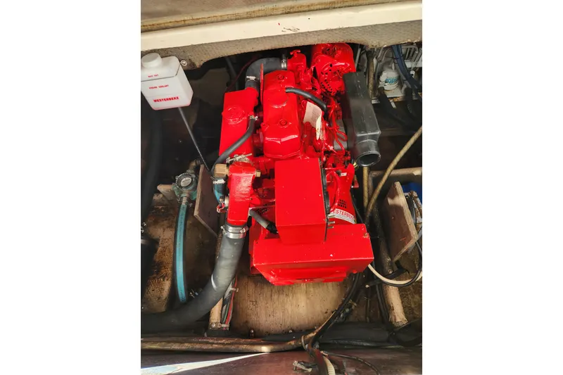 Slide: The Image of Engine compartment of a 1987 Luhrs 40 Convertible boat, featuring a red engine. - 43