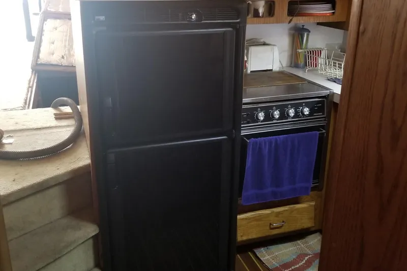 Slide: The Image of 1987 Luhrs 40 Convertible yacht kitchen with fridge, stove, and storage. - 8
