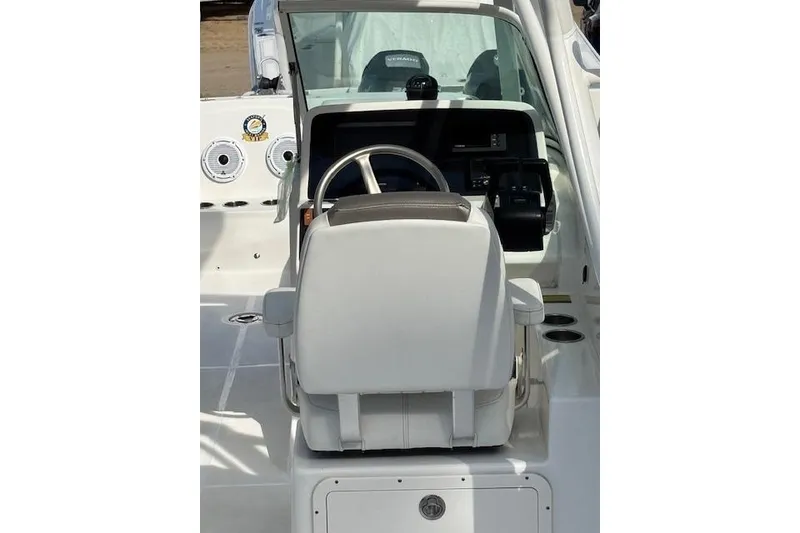 Slide: The Image of 2023 World Cat 230 DC boat cockpit with steering wheel and dashboard controls. - 6