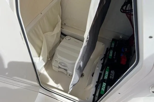 Slide: The Image of 2021 Key West 239 FS boat interior with portable toilet and battery storage. - 6