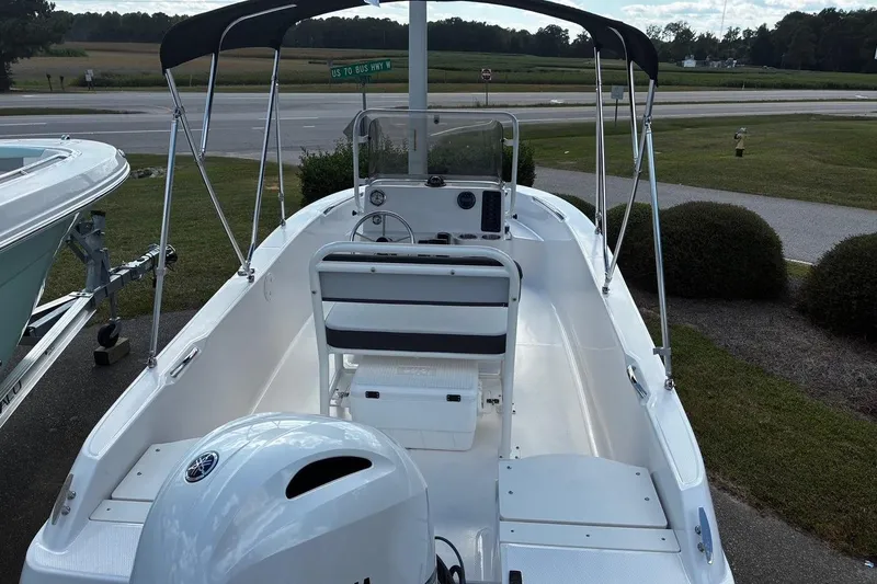 Slide: The Image of 2026 Robalo R160 Center Console boat with canopy, parked near a road. - 5