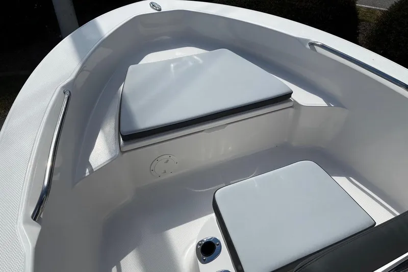 Slide: The Image of 2026 Robalo R160 Center Console boat interior with cushioned seating and stainless steel railings. - 7