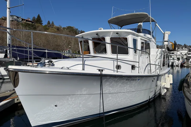 Slide: The Image of 2020 Helmsman Trawlers 38E docked in a marina under clear blue skies. - 1