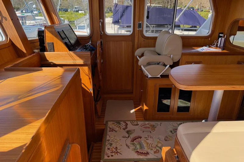 Slide: The Image of Interior of 2020 Helmsman Trawlers 38E, featuring wood finishes and comfortable seating. - 14