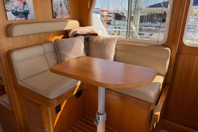 Slide: The Image of Interior of 2020 Helmsman Trawlers 38E with cozy seating and wooden table. - 16