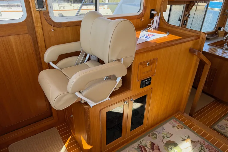 Slide: The Image of Helmsman Trawlers 38E 2020 interior with beige captain's chair and wooden cabinetry. - 18
