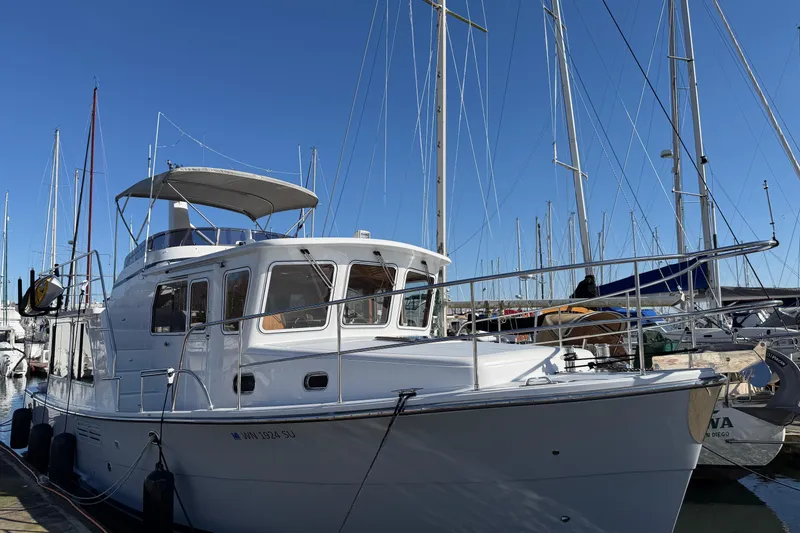 Slide: The Image of 2020 Helmsman Trawlers 38E yacht docked at marina under clear blue sky. - 2