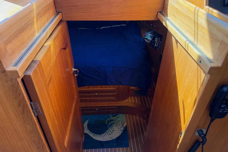Slide: The Image of Cozy cabin interior of 2020 Helmsman Trawlers 38E with wooden finish and blue bedding. - 21