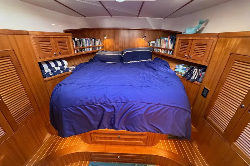 Slide: The Image of Cozy cabin interior of 2020 Helmsman Trawlers 38E with wooden finish and blue bedding. - 22