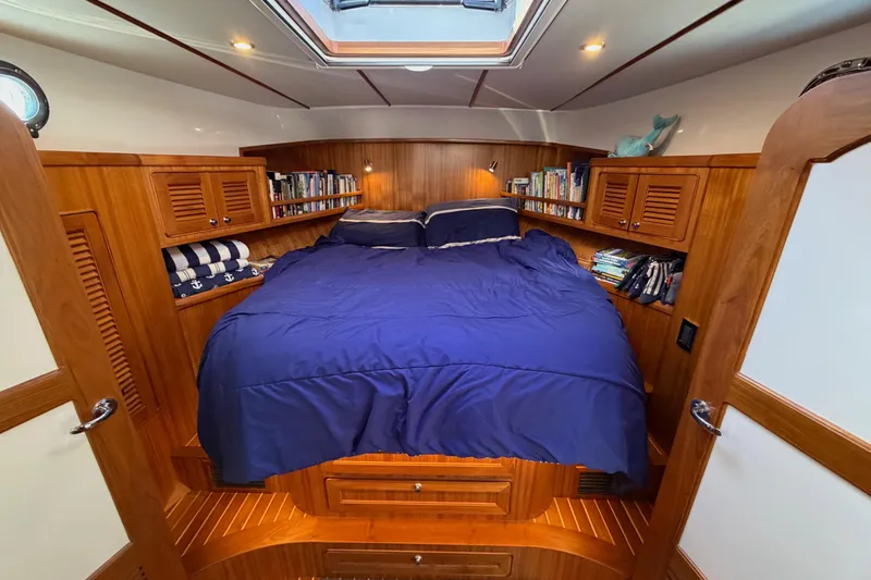 Slide: The Image of Cozy cabin interior of 2020 Helmsman Trawlers 38E with blue bedding and wooden accents. - 23