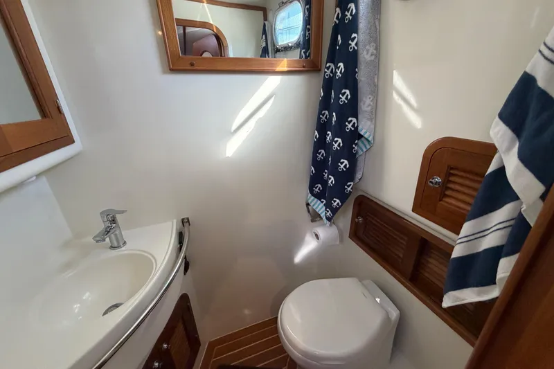 Slide: The Image of Bathroom interior of 2020 Helmsman Trawlers 38E with sink, toilet, and nautical decor. - 26