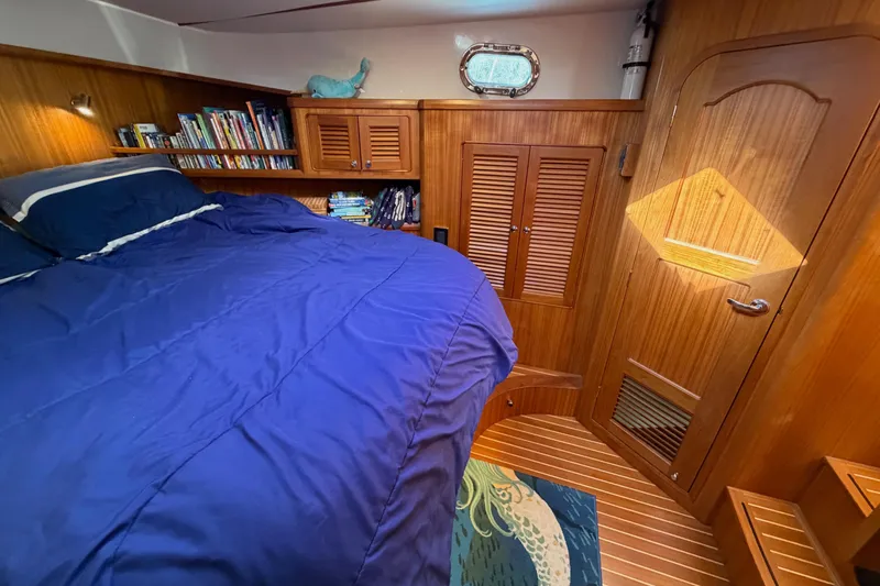 Slide: The Image of Cozy cabin interior of 2020 Helmsman Trawlers 38E with blue bedding and wooden accents. - 27