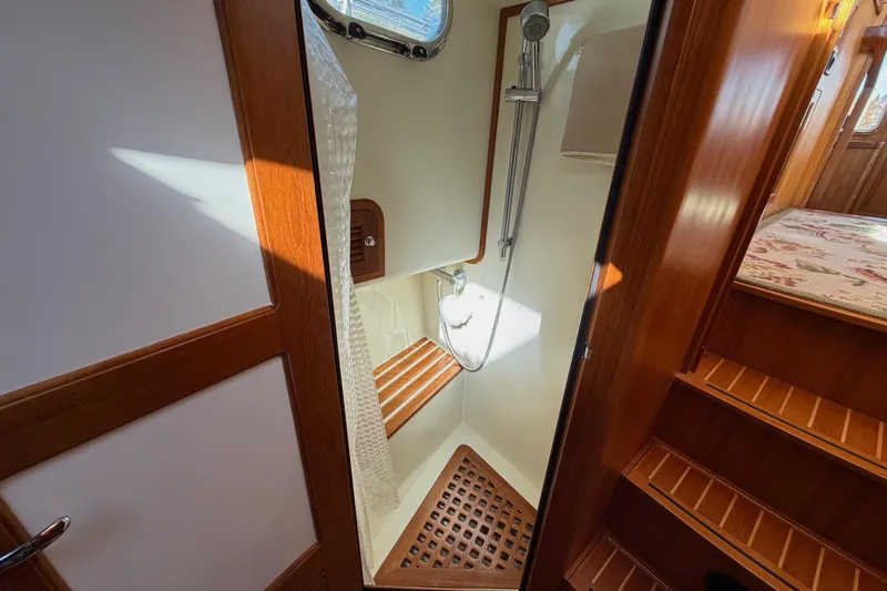 Slide: The Image of 2020 Helmsman Trawlers 38E shower area with wooden accents and modern fixtures. - 28