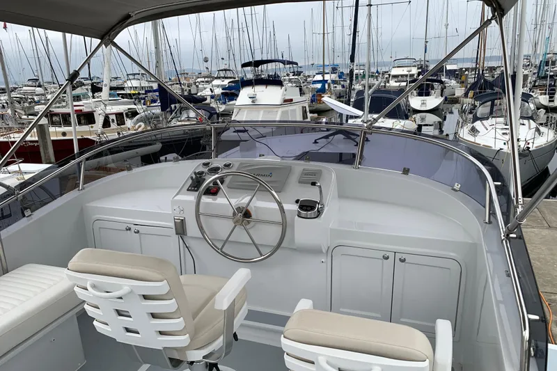 Slide: The Image of Helmsman Trawlers 38E 2020 model at marina, featuring helm station and seating. - 32