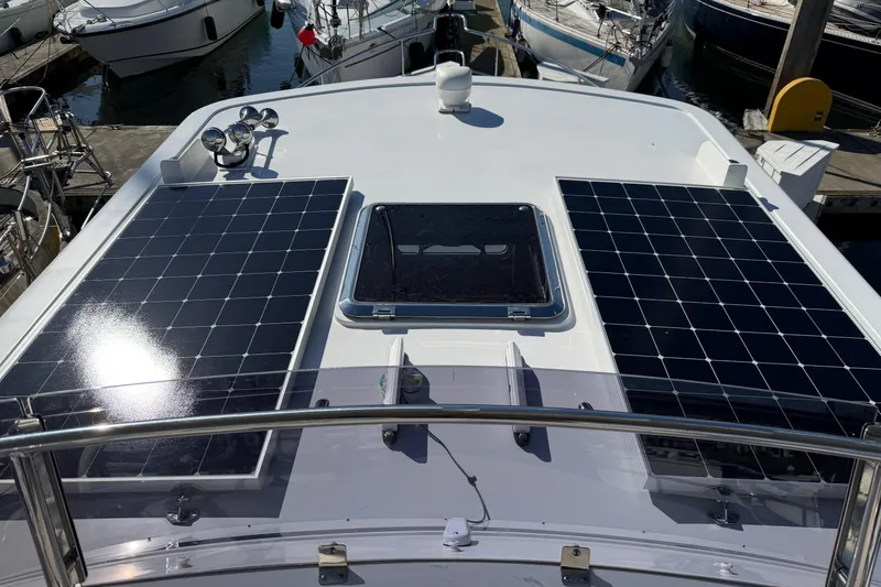 Slide: The Image of Helmsman Trawlers 38E 2020 yacht with solar panels on deck, docked at marina. - 38