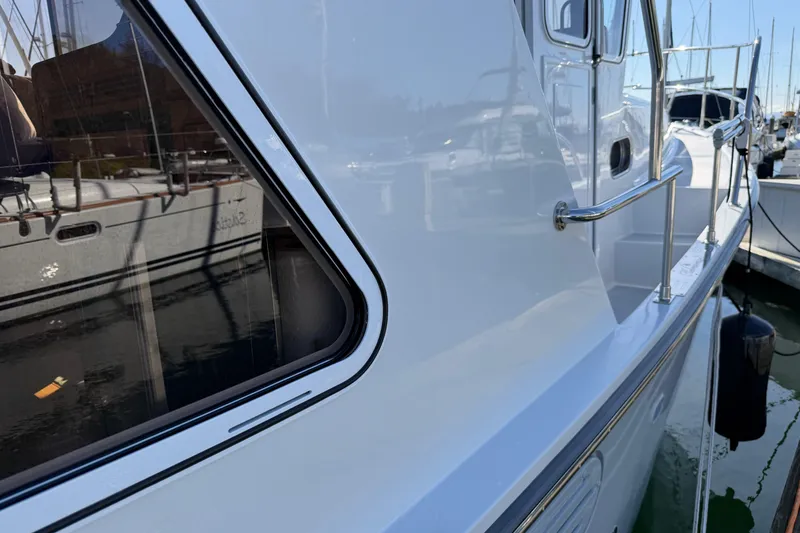 Slide: The Image of Helmsman Trawlers 38E 2020 model, side view with window and railing, docked at marina. - 39