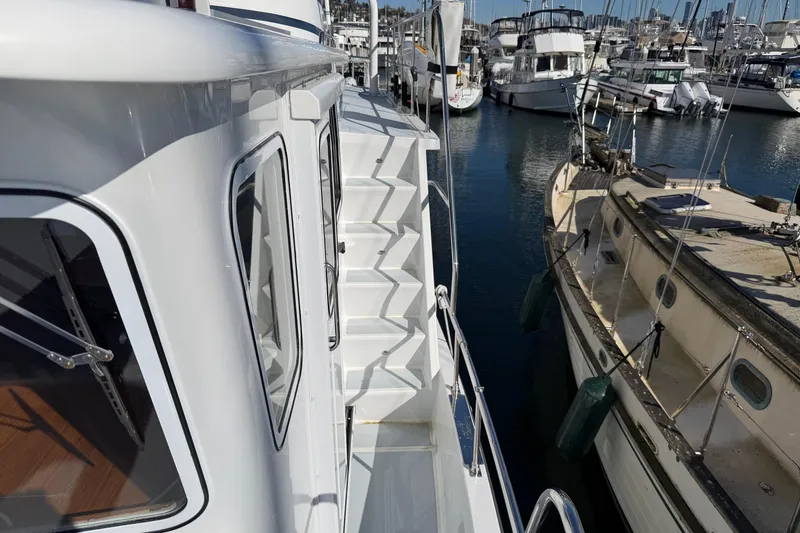 Slide: The Image of Helmsman Trawlers 38E 2020 yacht docked at marina, side view with stairs. - 44