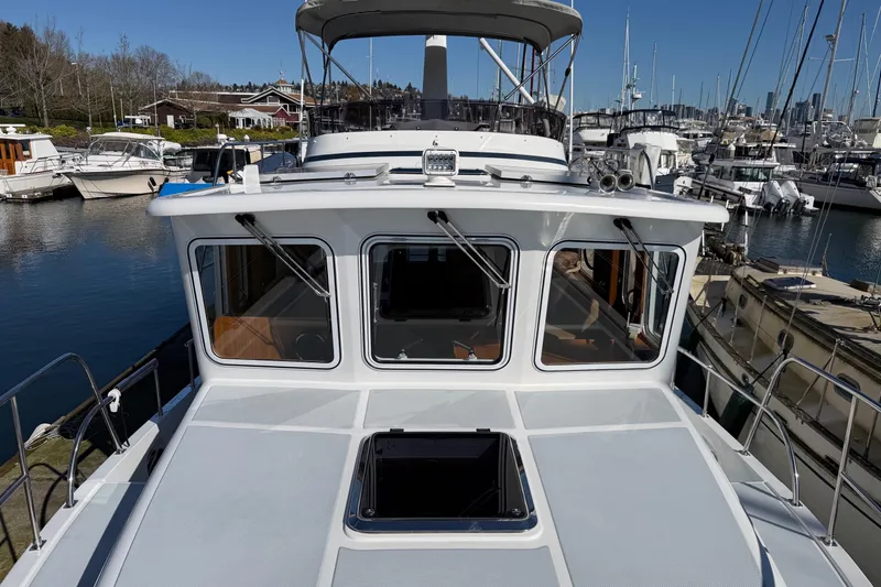 Slide: The Image of 2020 Helmsman Trawlers 38E yacht docked at marina, showcasing sleek design and spacious deck. - 45