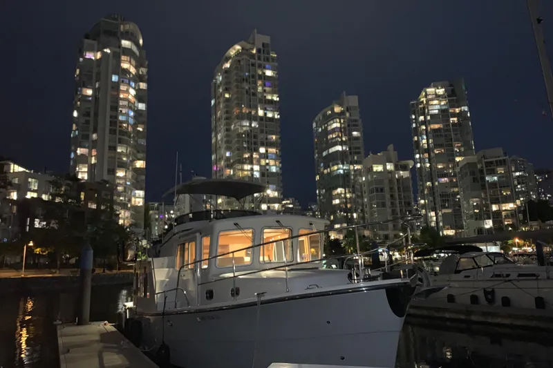 Slide: The Image of Helmsman Trawlers 38E 2020 yacht docked at night with illuminated city skyline. - 50