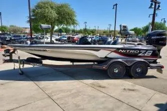 The Image of 2011 Nitro Z-8 boat on trailer in outdoor parking lot. - 1