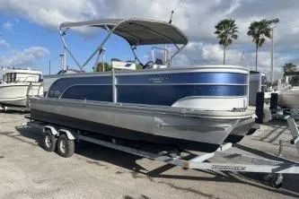 Slide: The Image of 2023 Suntracker G3 Select 322 CC pontoon boat on trailer, parked outdoors. - 2