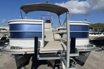 Slide: The Image of 2023 Suntracker G3 Select 322 CC pontoon boat on trailer under blue sky. - 3