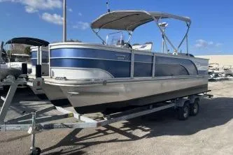Slide: The Image of 2023 Suntracker G3 Select 322 CC pontoon boat on trailer under clear blue sky. - 4
