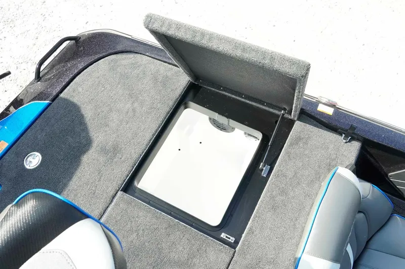 Slide: The Image of Open storage compartment on 2026 Skeeter ZXE21 boat with gray carpeted interior. - 25