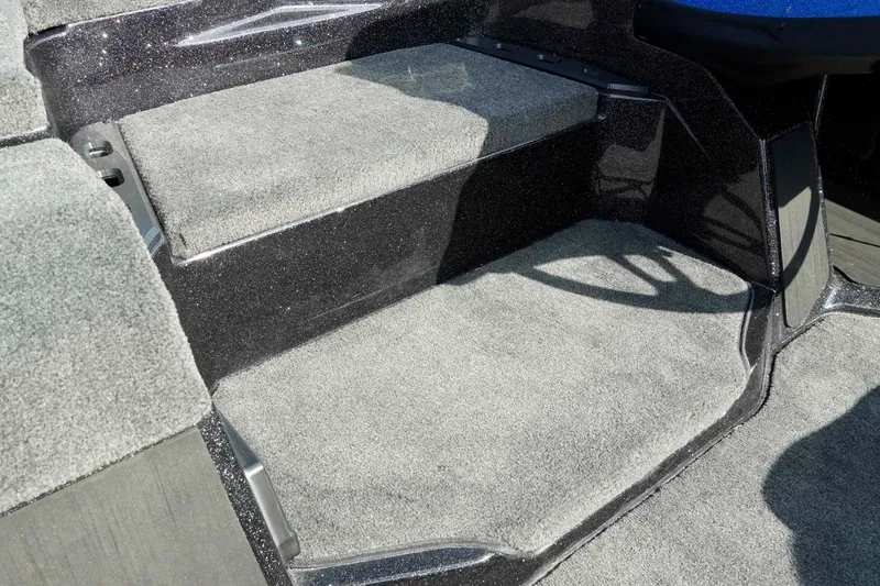 Slide: The Image of Carpeted steps on a 2026 Skeeter ZXE21 boat interior. - 29