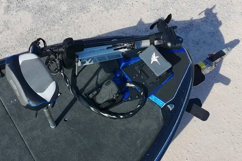 Slide: The Image of 2026 Skeeter ZXE21 boat deck with trolling motor and seat, on a sandy surface. - 4