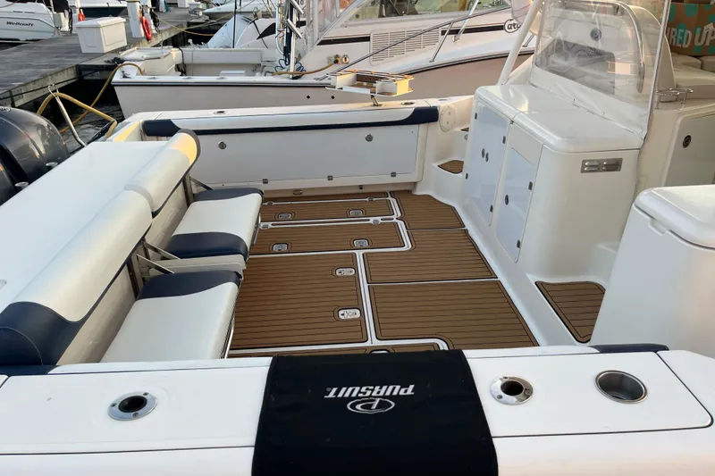 Slide: The Image of 2009 Pursuit OS 375 Offshore boat interior with seating and teak flooring. - 11