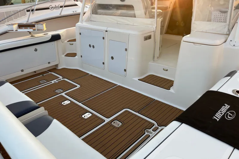 Slide: The Image of 2009 Pursuit OS 375 Offshore boat interior with teak flooring and storage compartments. - 12