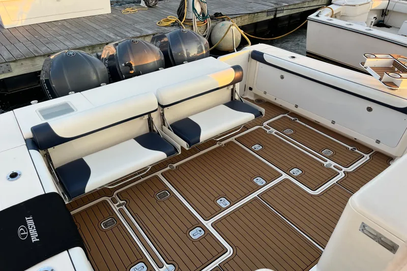 Slide: The Image of 2009 Pursuit OS 375 Offshore boat with cushioned seating and teak-style deck. - 13