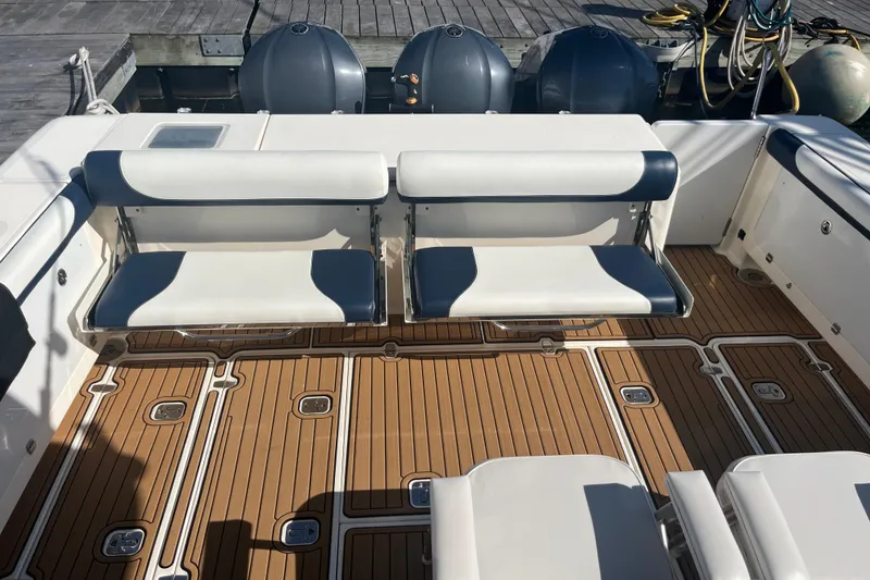 Slide: The Image of 2009 Pursuit OS 375 Offshore boat deck with cushioned seating and teak flooring. - 14