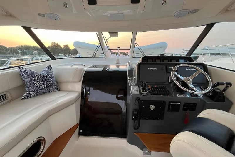 Slide: The Image of Interior of a 2009 Pursuit OS 375 Offshore boat with helm and seating area. - 16