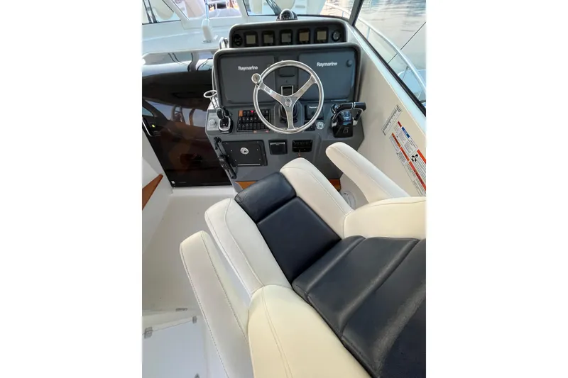 Slide: The Image of Helm of 2009 Pursuit OS 375 Offshore boat with Raymarine electronics and cushioned seating. - 17