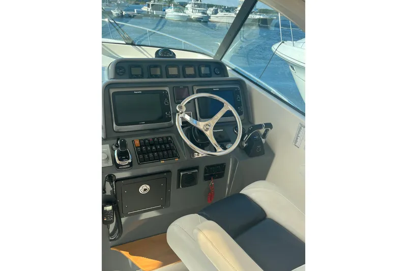 Slide: The Image of 2009 Pursuit OS 375 Offshore helm with steering wheel and navigation controls. - 18