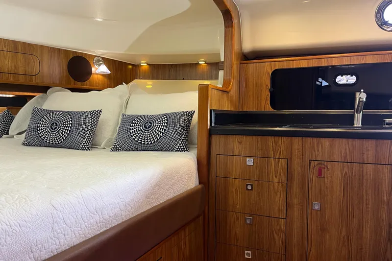 Slide: The Image of Luxurious cabin interior of 2009 Pursuit OS 375 Offshore boat with bed and kitchenette. - 30