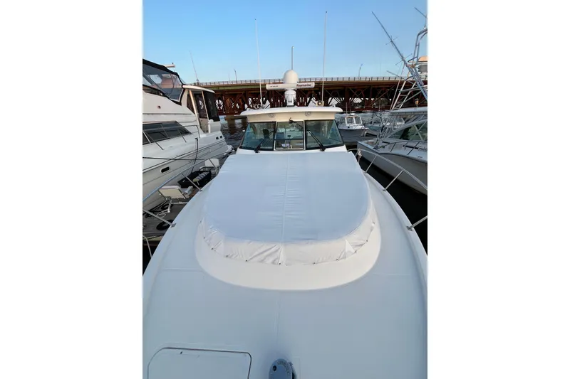 Slide: The Image of 2009 Pursuit OS 375 Offshore boat docked at marina, showcasing sleek design and spacious deck. - 32