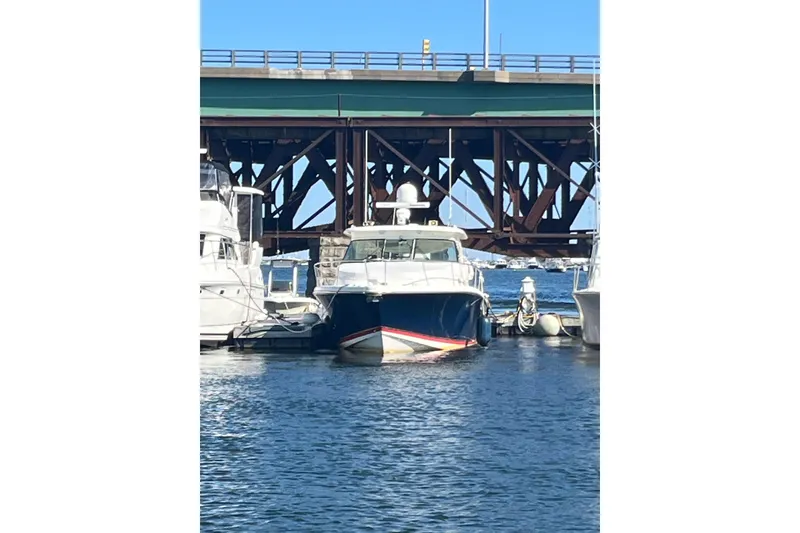 Slide: The Image of 2009 Pursuit OS 375 Offshore boat docked near a bridge on a sunny day. - 43