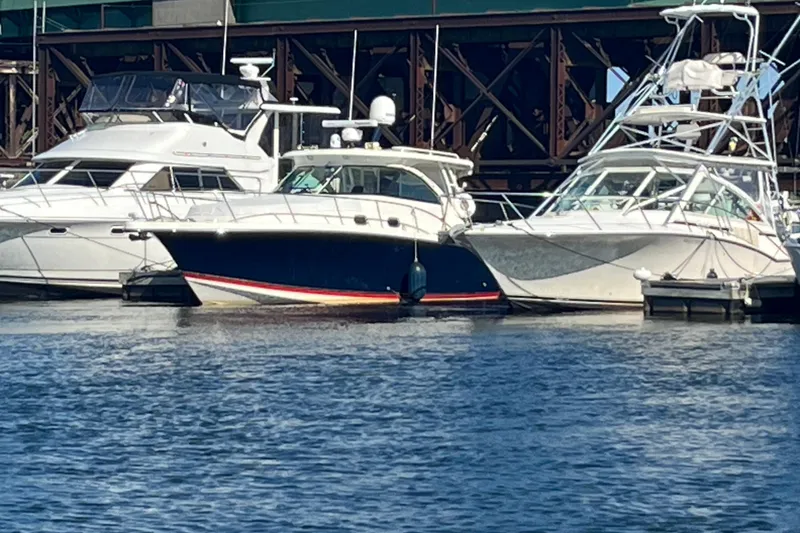Slide: The Image of 2009 Pursuit OS 375 Offshore boat docked between two other boats. - 44