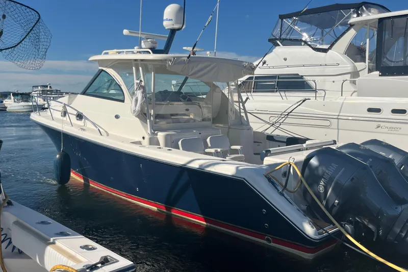 Slide: The Image of 2009 Pursuit OS 375 Offshore boat docked, featuring Yamaha engines and sleek design. - 5