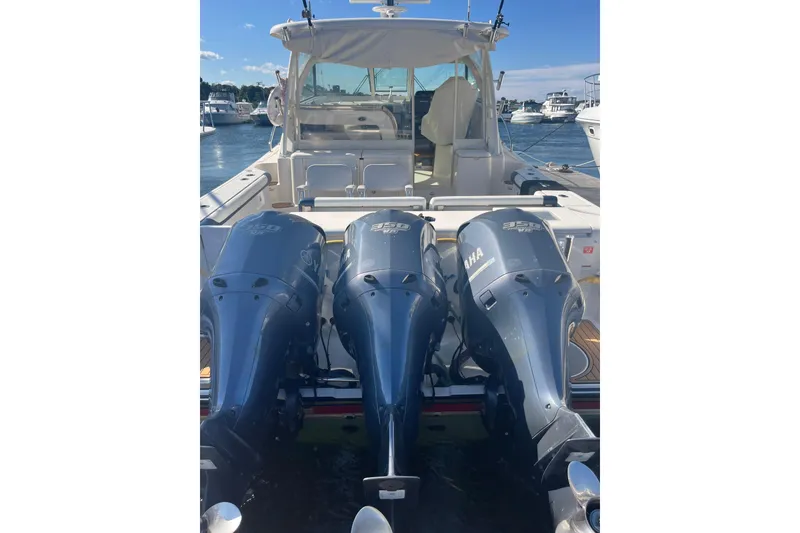 Slide: The Image of 2009 Pursuit OS 375 Offshore boat with triple Yamaha outboard engines docked at marina. - 7