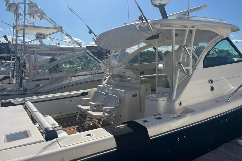 Slide: The Image of 2009 Pursuit OS 375 Offshore boat docked, featuring spacious seating and modern design. - 9