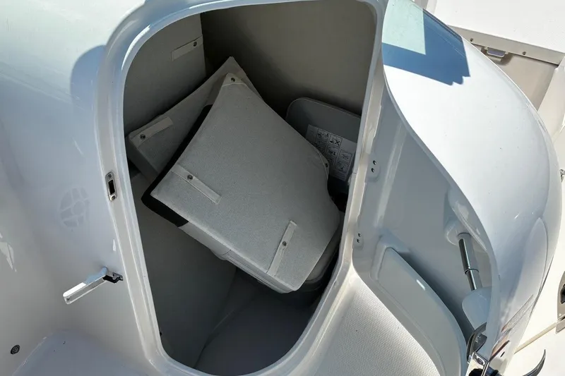 Slide: The Image of Storage compartment of 2025 Robalo R207 Dual Console boat with cushions inside. - 17
