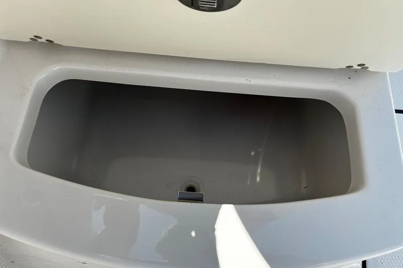 Slide: The Image of Open storage compartment on 2025 Robalo R207 Dual Console boat. - 18