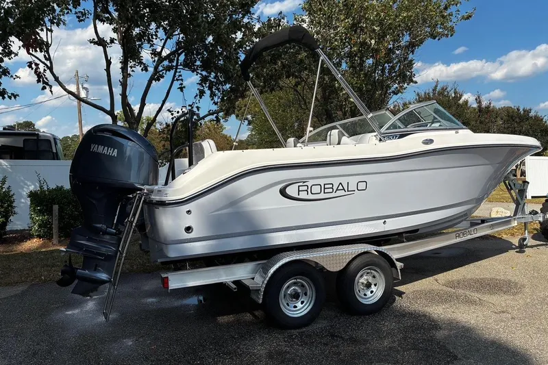 Slide: The Image of 2025 Robalo R207 Dual Console boat on trailer with Yamaha outboard motor. - 2
