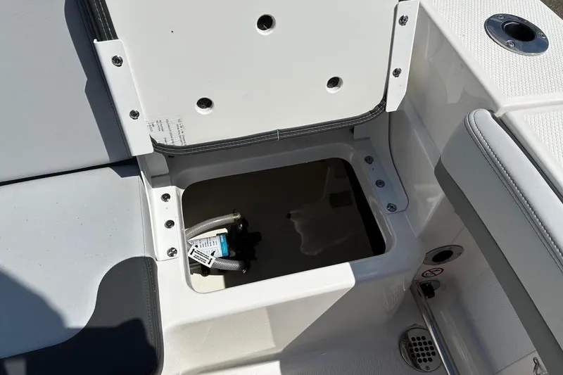 Slide: The Image of Open storage compartment on 2025 Robalo R207 Dual Console boat interior. - 20