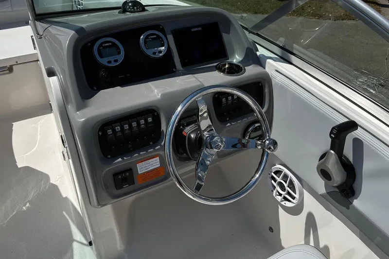 Slide: The Image of 2025 Robalo R207 Dual Console boat dashboard with steering wheel and controls. - 6