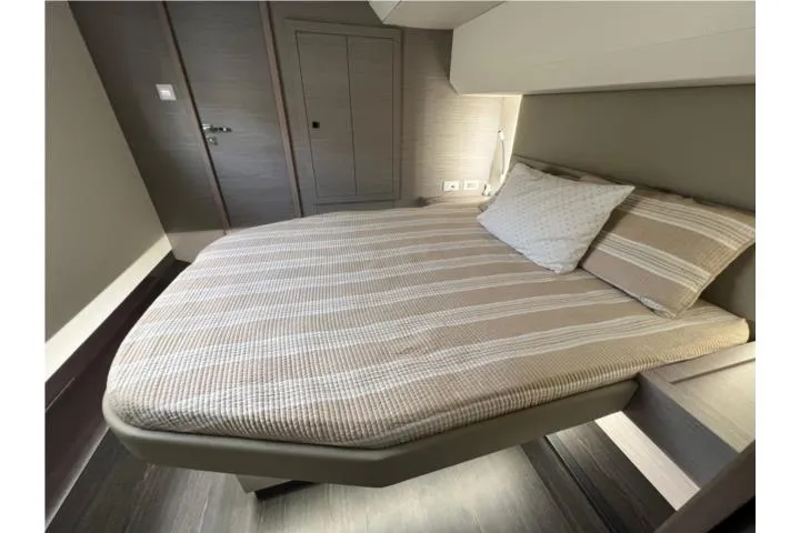 Slide: The Image of 2024 Fountaine Pajot MY6 yacht bedroom with modern design and striped bedding. - 19